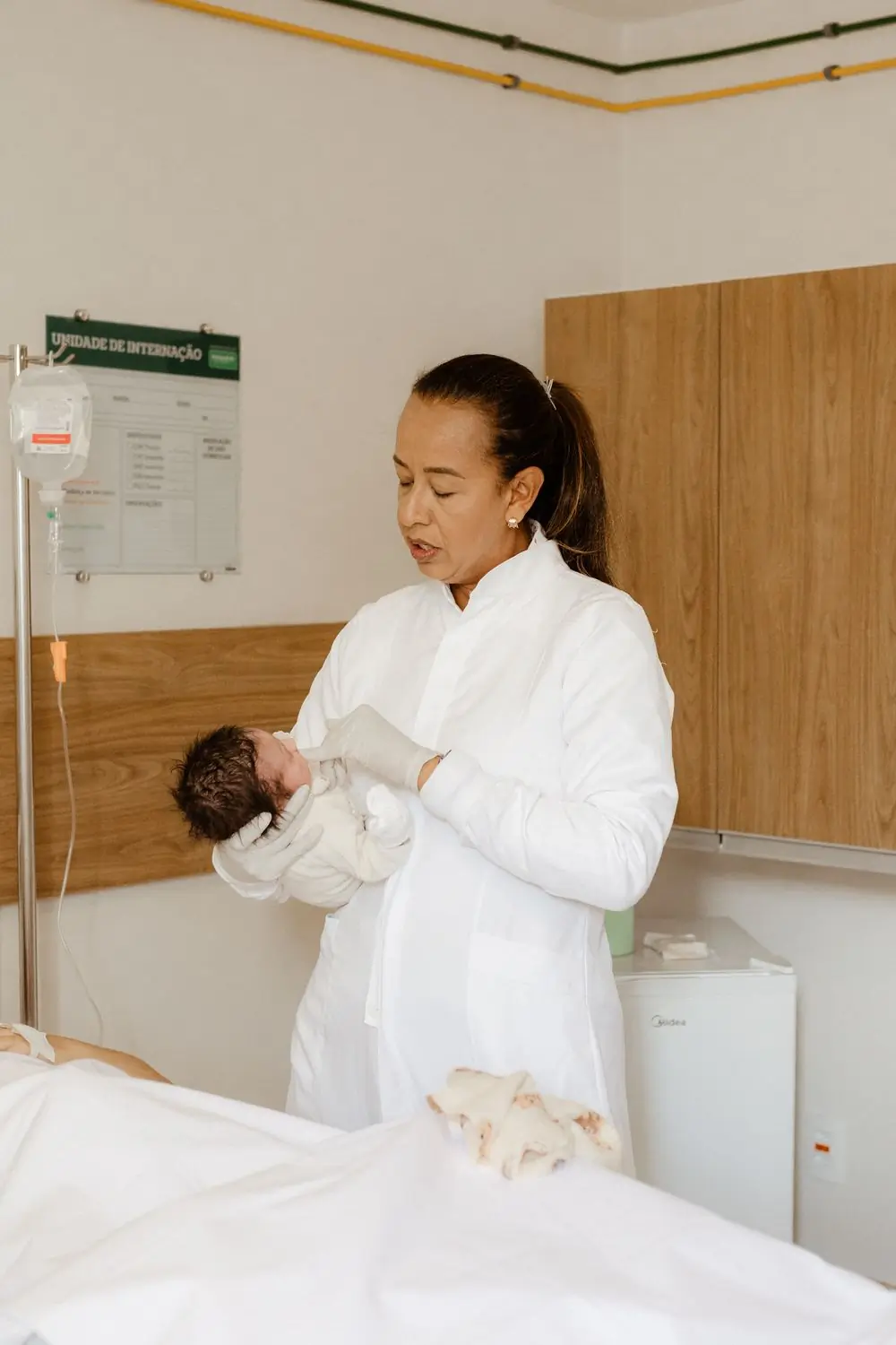 A neonatologist holding a newborn on the postnatal round