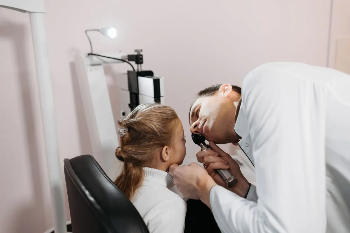 A paediatric ENT consultant examining a young girl