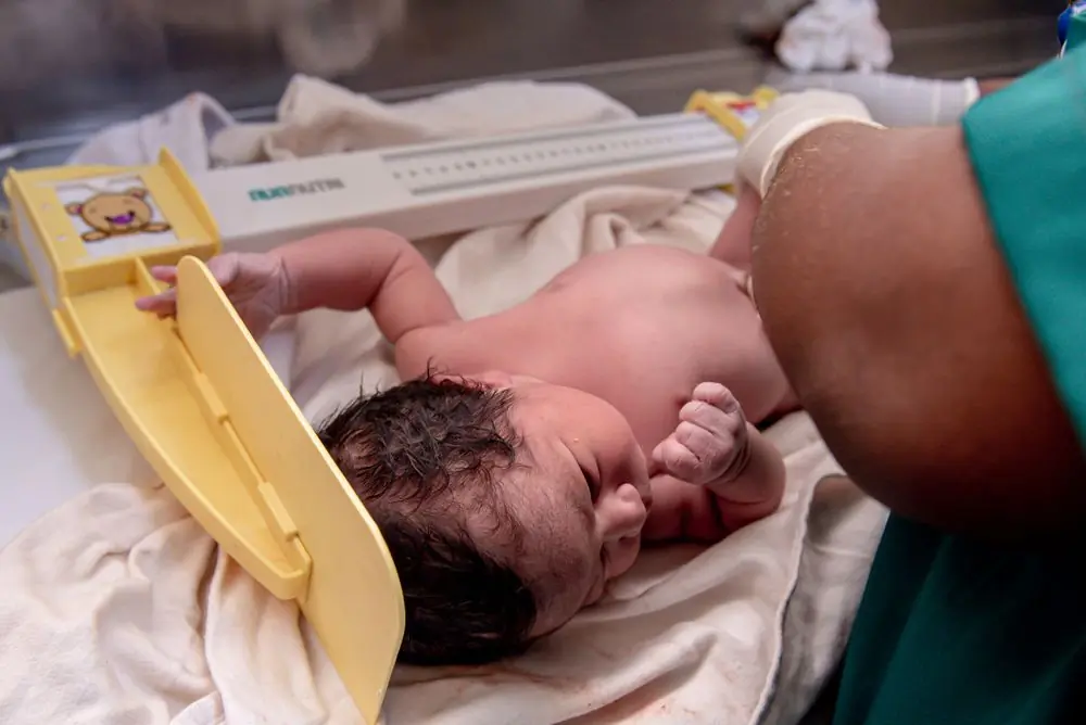 A newborn being weighed in the hospital's own nursery