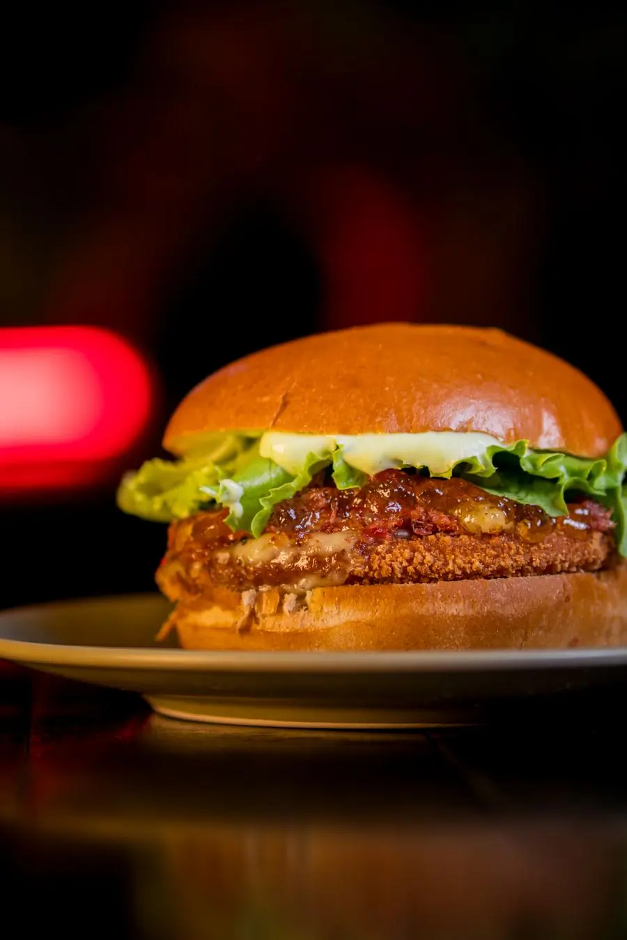A juicy beef burger with melted cheese on a dark board