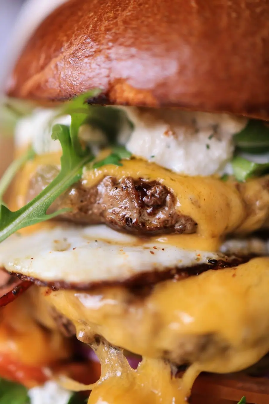 A close-up of a burger with melted cheese