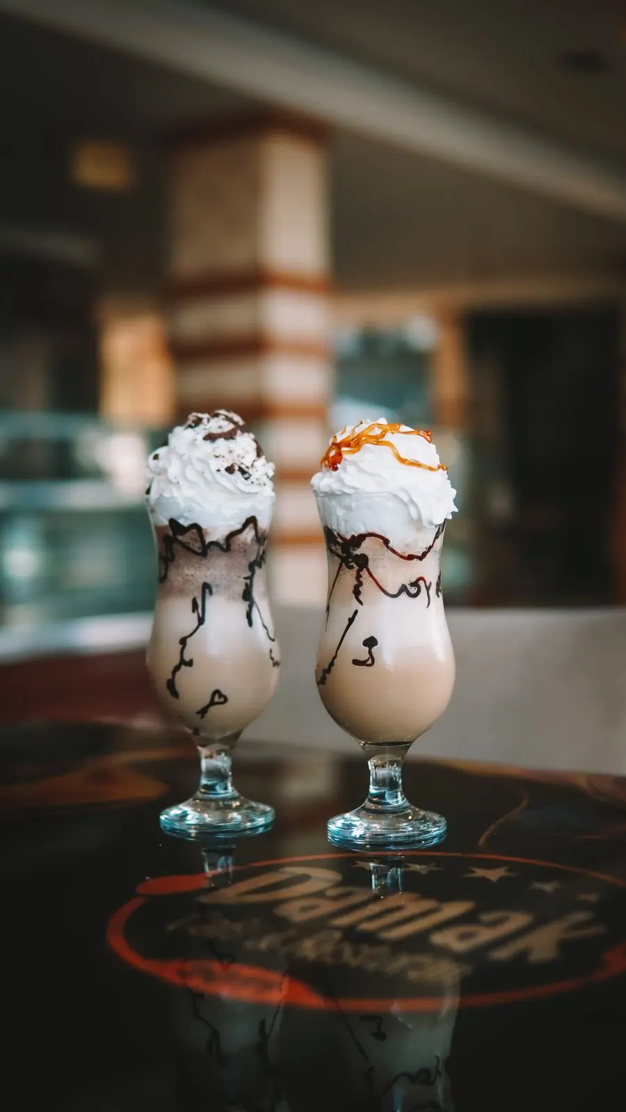 Three milkshakes topped with whipped cream