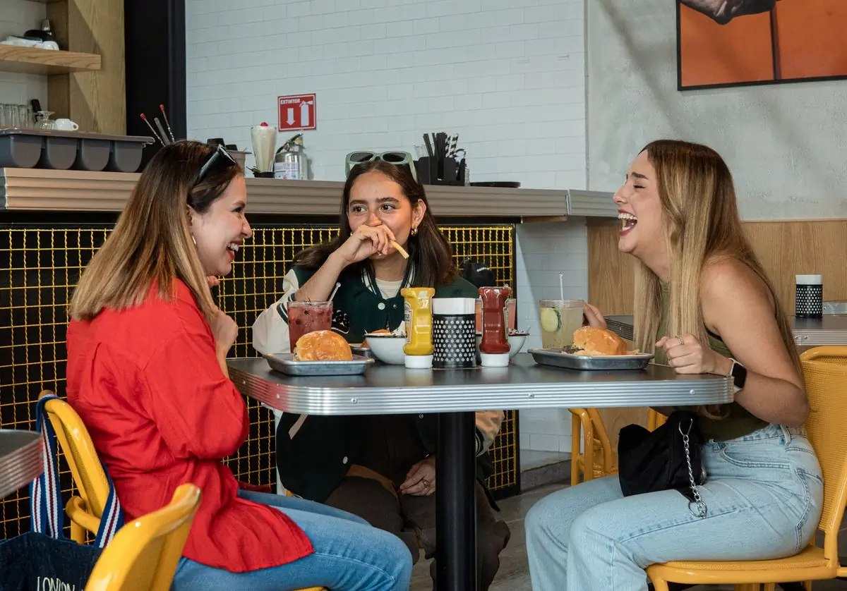 Friends laughing over burgers at a table