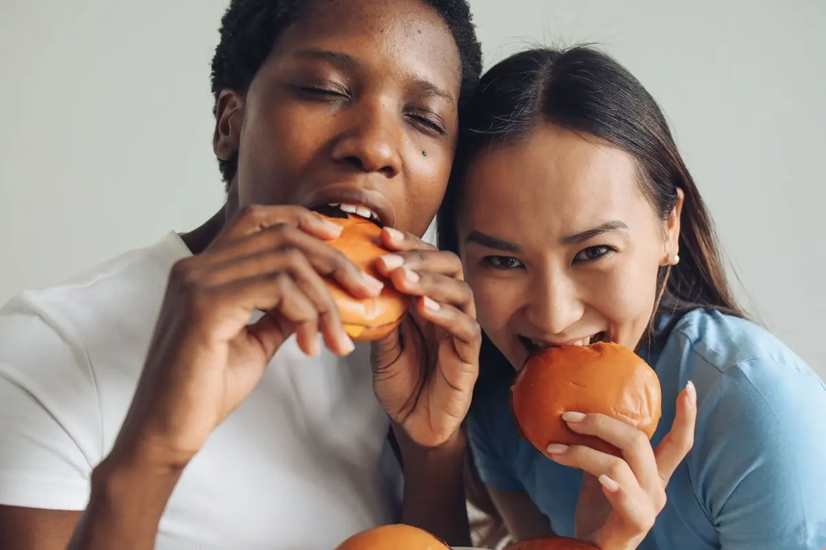 Two guests happily eating burgers