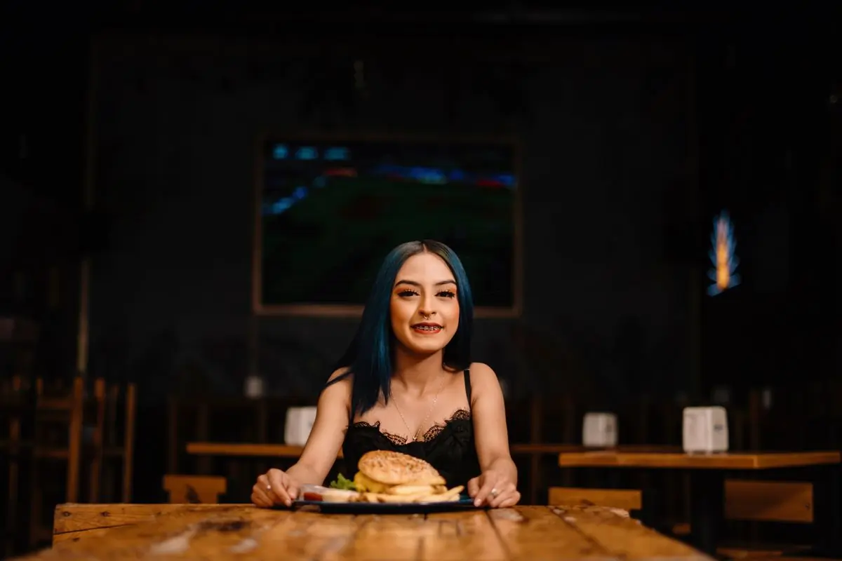 A guest halfway through a burger in the dining room