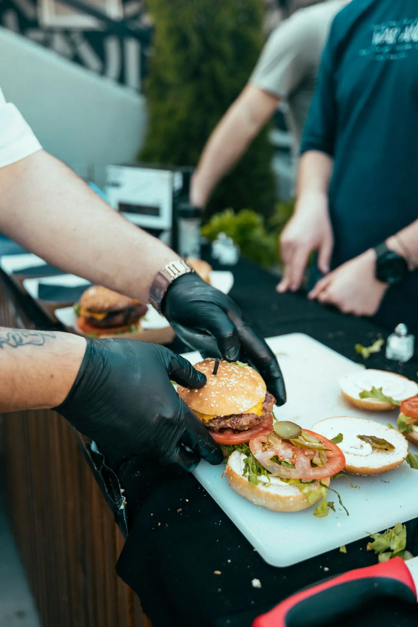 A cook building burgers on the pass