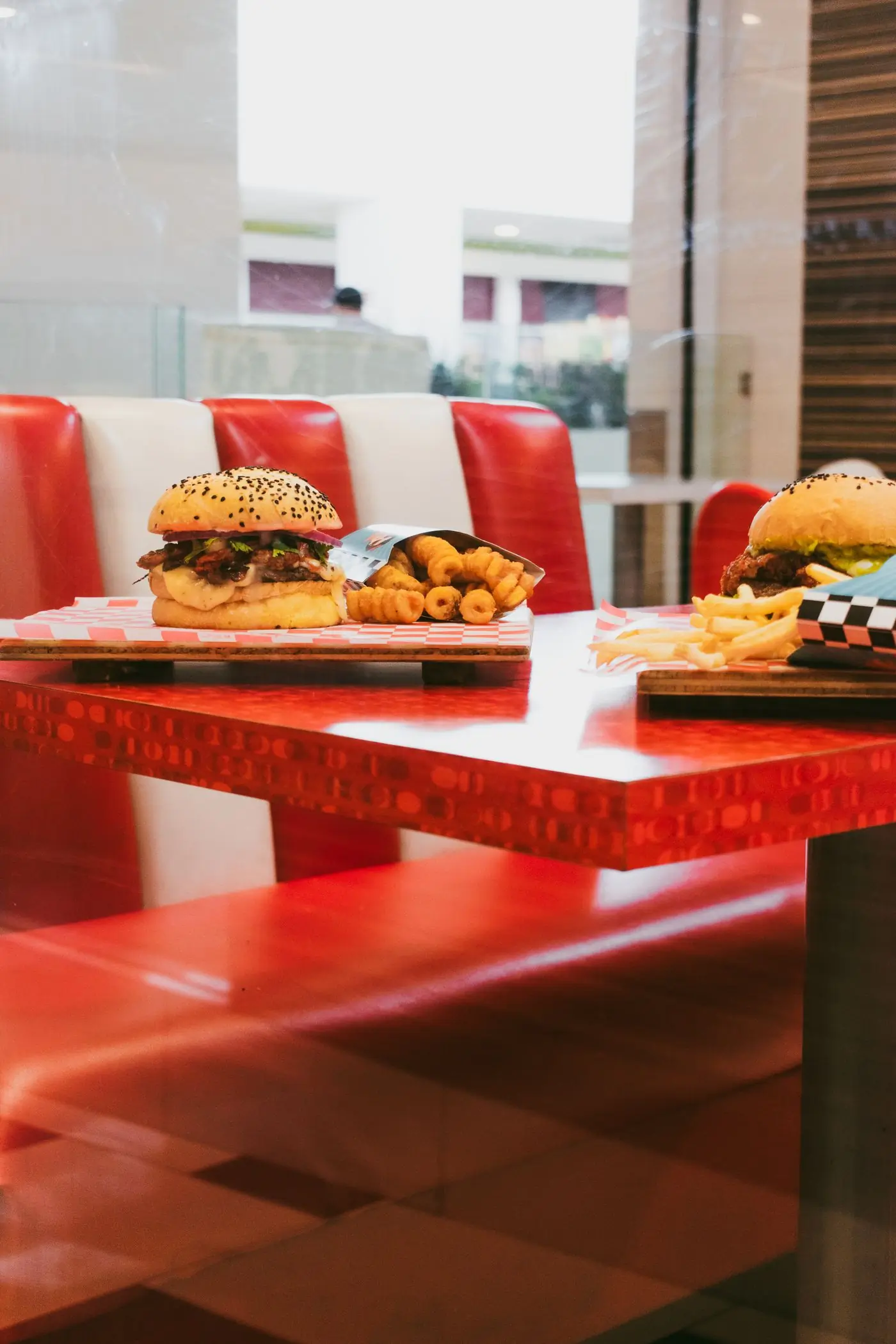 Red booths and a burger on the table in the dining room