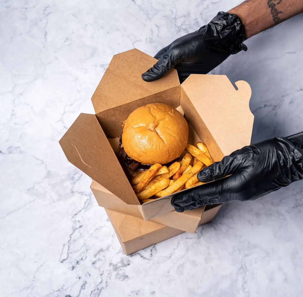 A burger and fries packed into a takeaway box