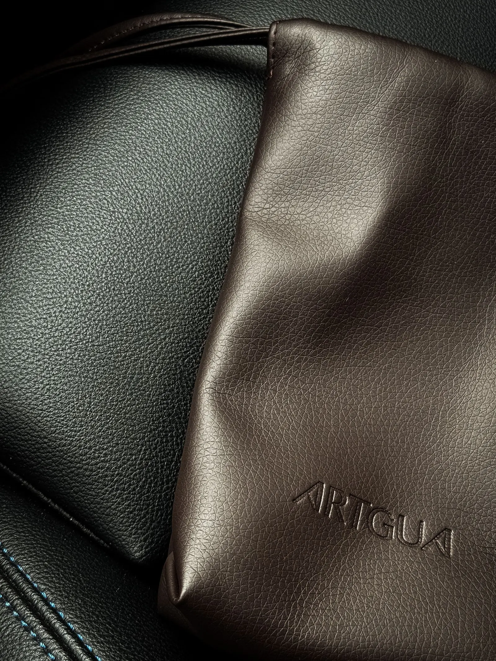 Folds of dark and bronze leather catching a low raking light