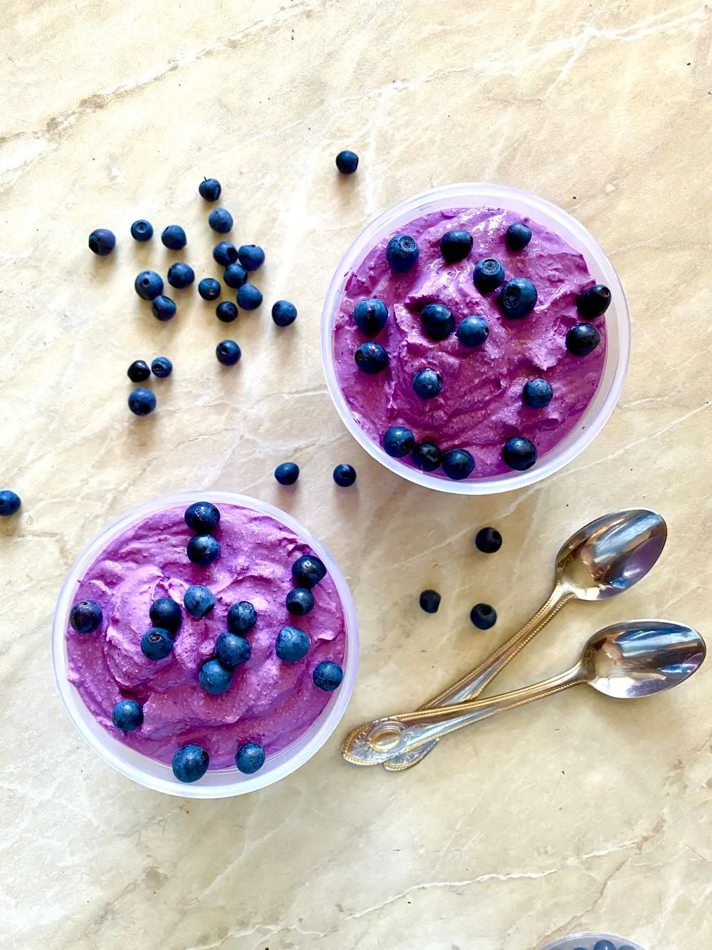 A deep magenta scoop of hibiscus sorbet in a pale bowl, beaded with frost