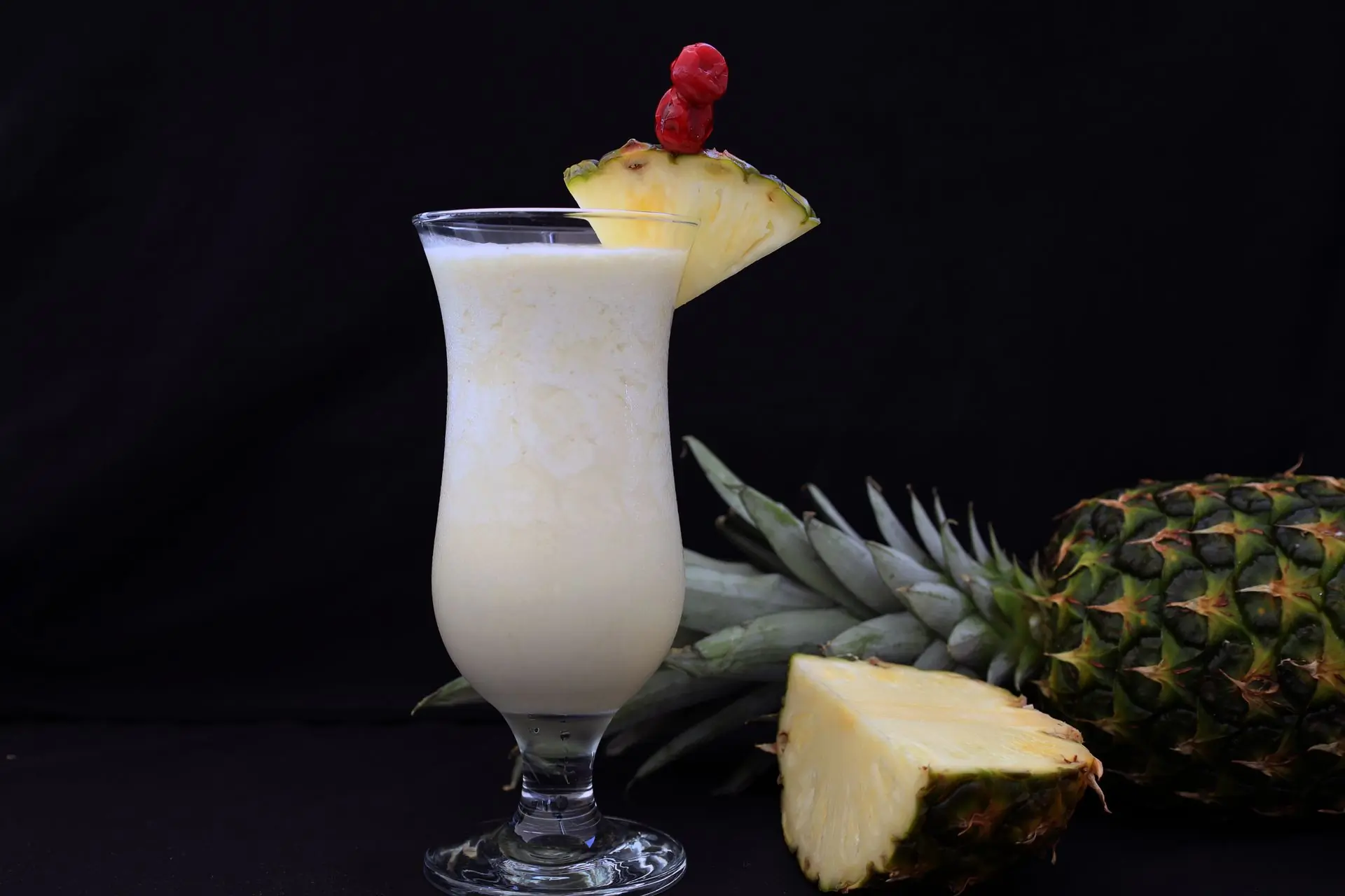 A creamy white coconut drink in a tall glass