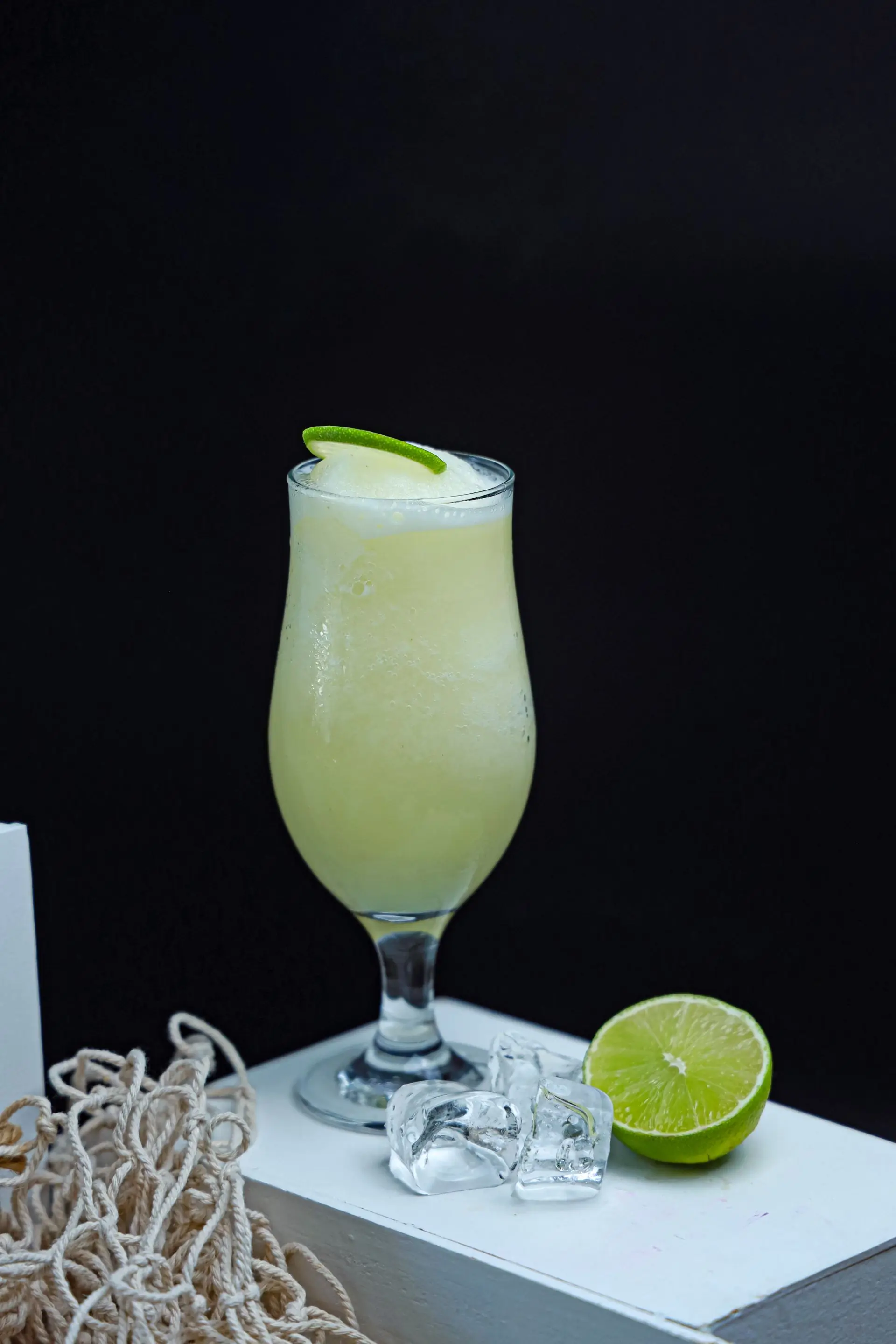 A fizzing glass of lime soda packed with ice and fresh lime wheels