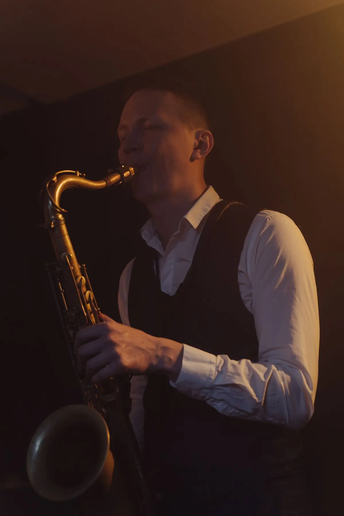 A saxophonist playing in a dimly lit venue