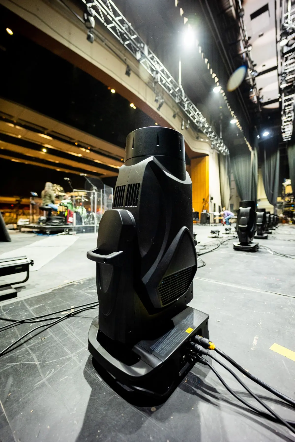 A moving-head lighting fixture standing in a venue before a show