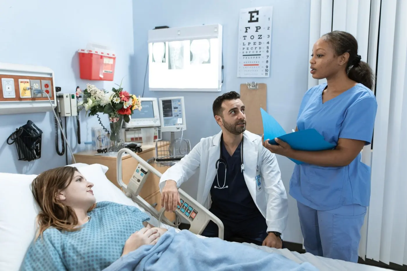 A doctor and a nurse going through a patient's chart at the bedside