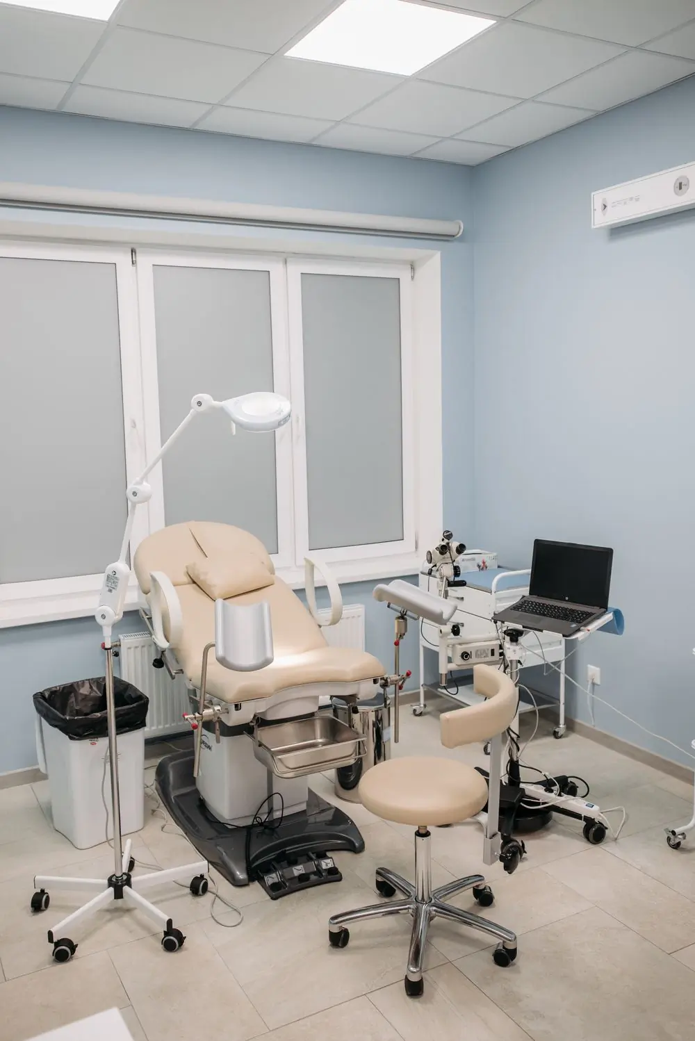A prepared consulting room with an examination couch and lamp