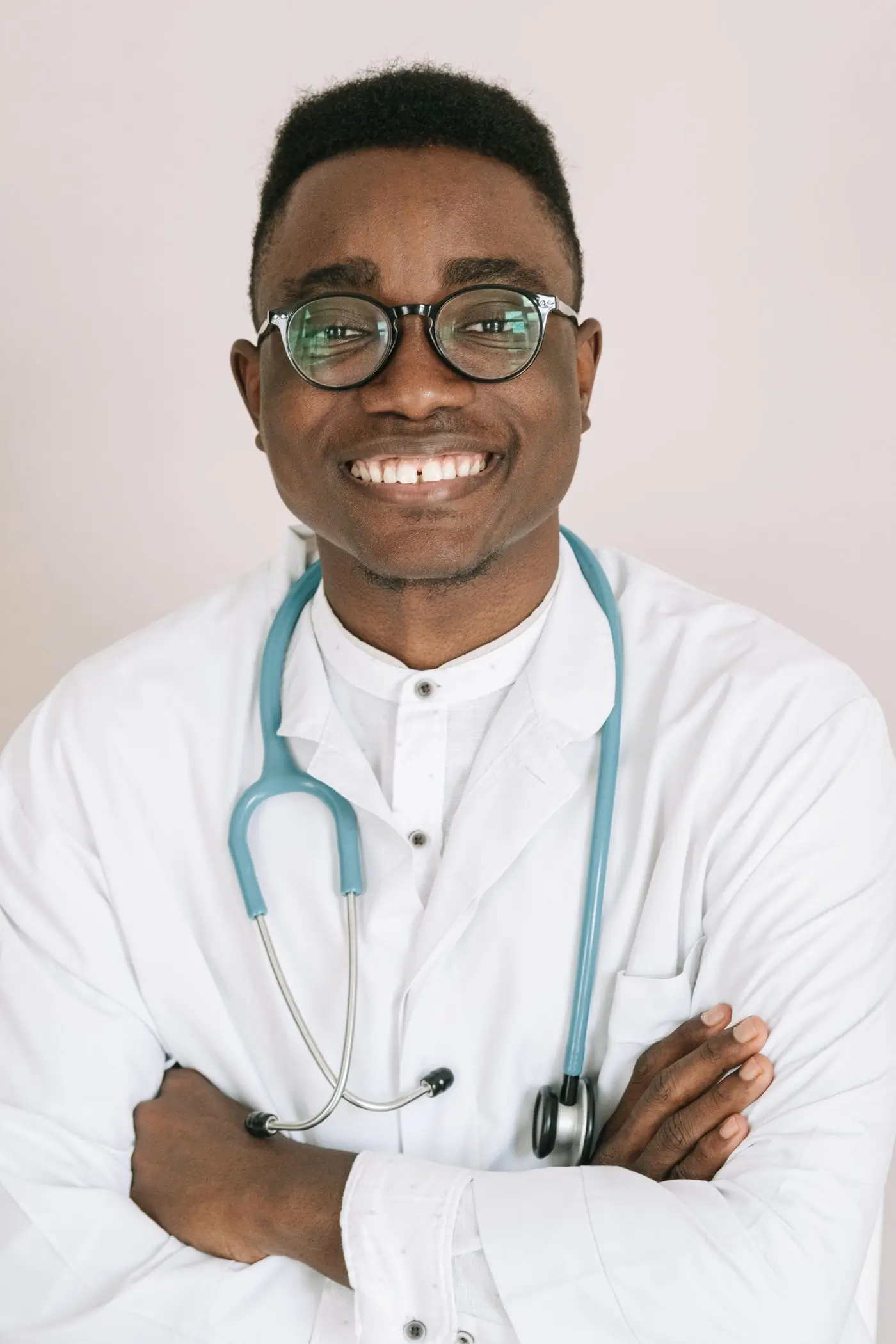 A smiling doctor in a white coat with a stethoscope around his neck