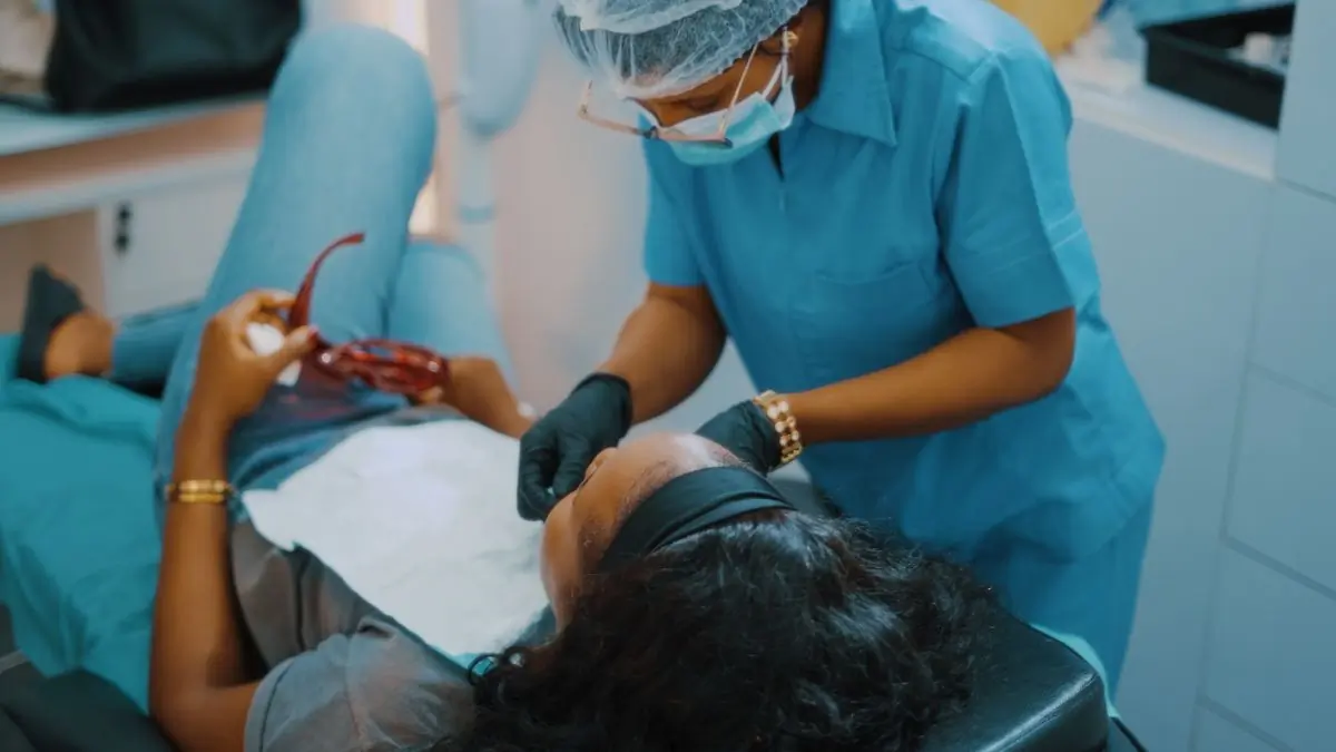A dentist examining a patient's teeth in a bright surgery