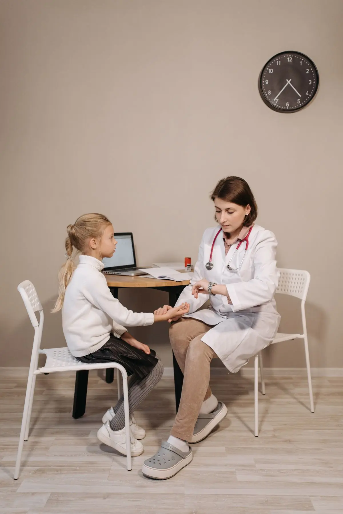 A paediatrician examining a young child in a bright consulting room