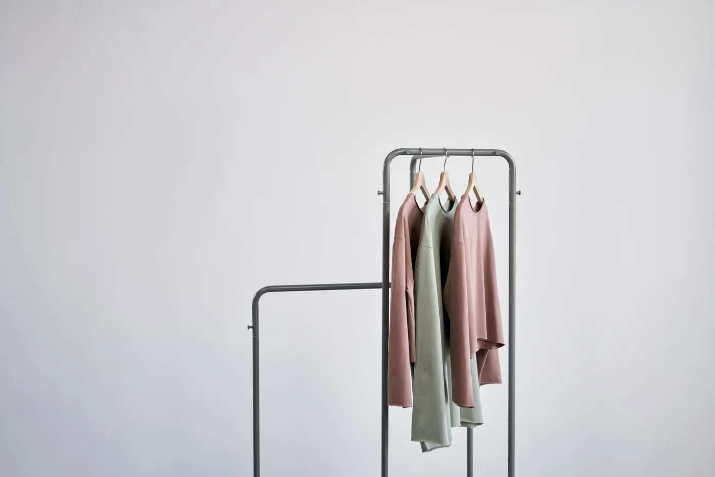 A minimal rail holding four quiet-coloured pieces