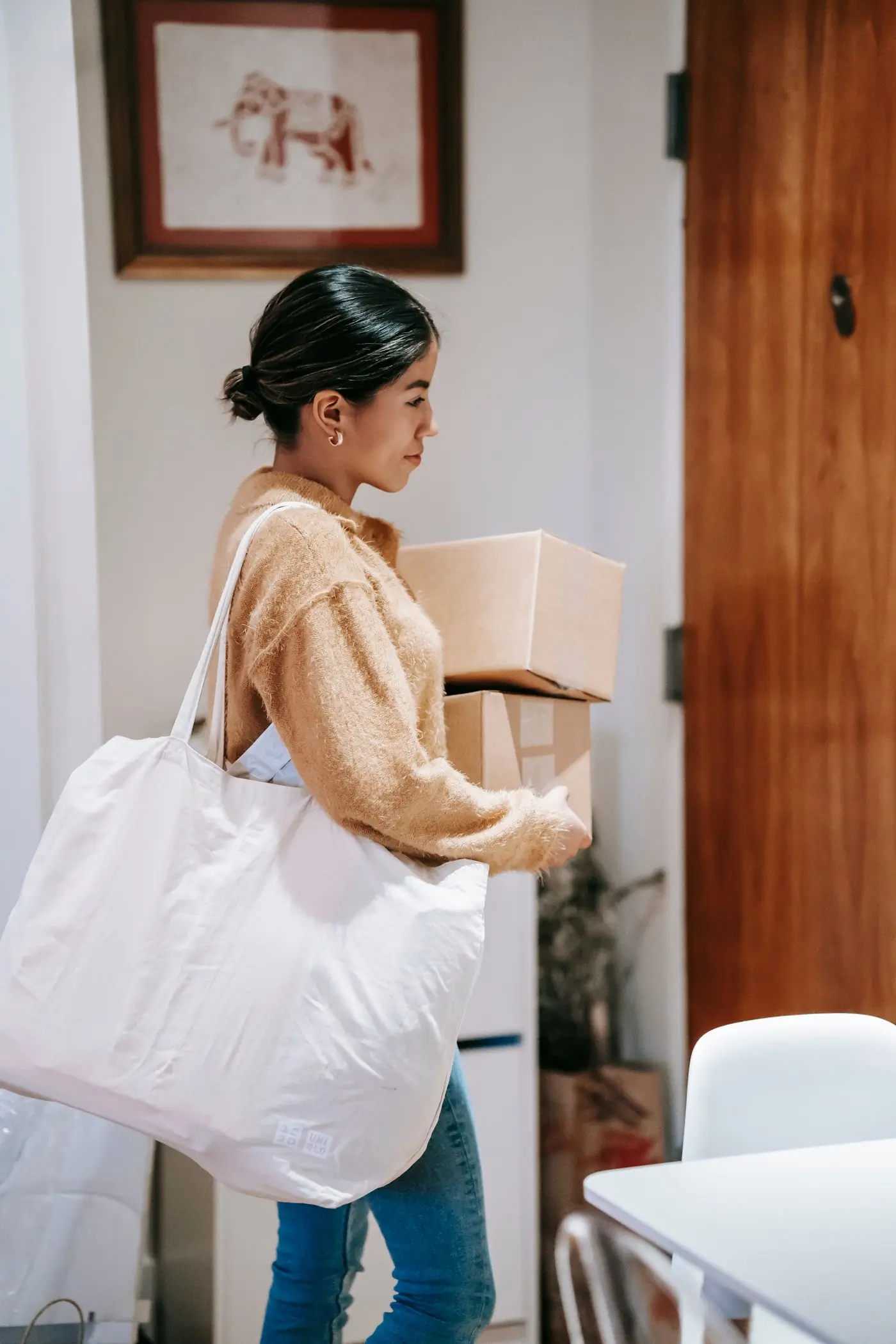 Someone carrying a cotton tote and a wrapped parcel