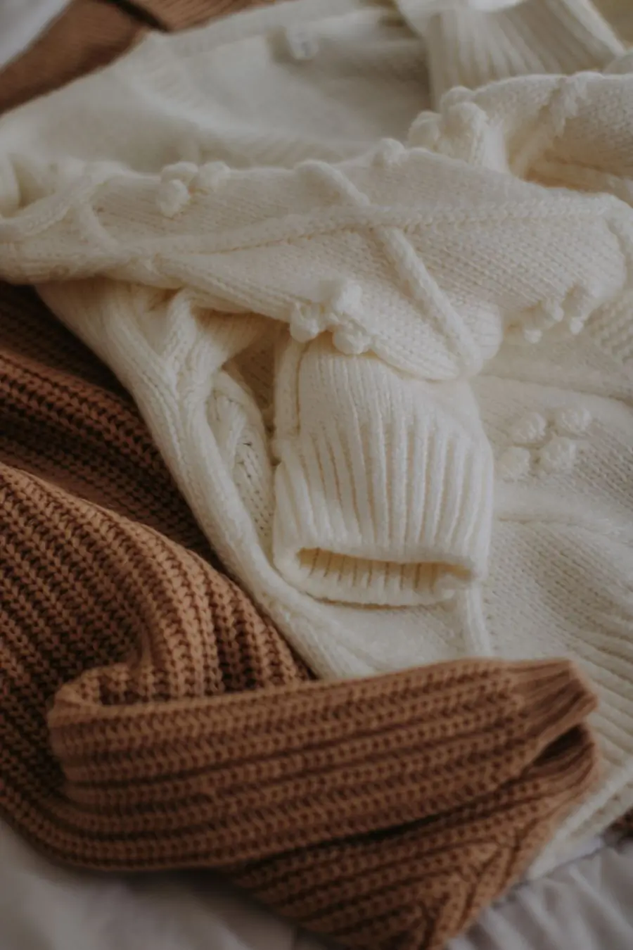 A cream cable-knit cardigan photographed close
