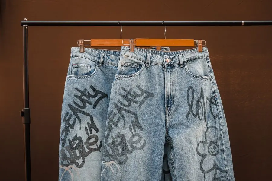 Hand-painted denim shorts on wooden hangers