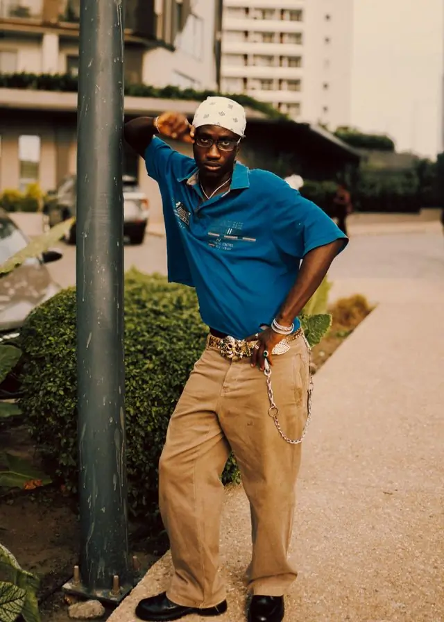 A man in a blue polo and mustard trousers on the street