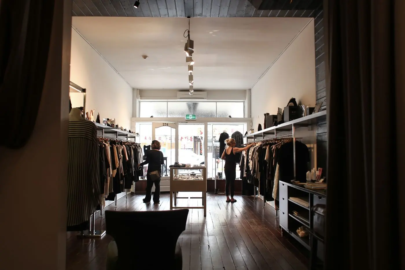 Customers browsing a long shop floor with a timber counter