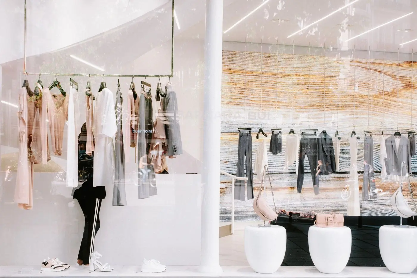 A bright shop with pale rails and a mirrored wall