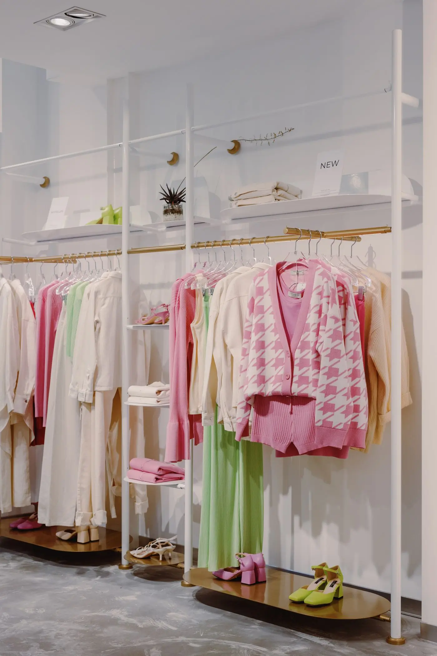 Cardigans and knitwear hung on a brass rail
