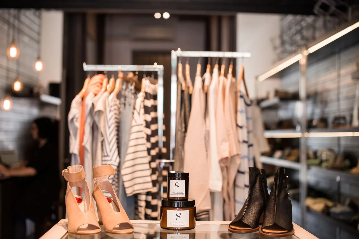 A shop floor with rails, shoes and folded knitwear