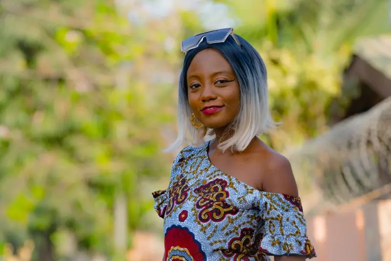 A customer in a printed off-shoulder top, smiling outdoors