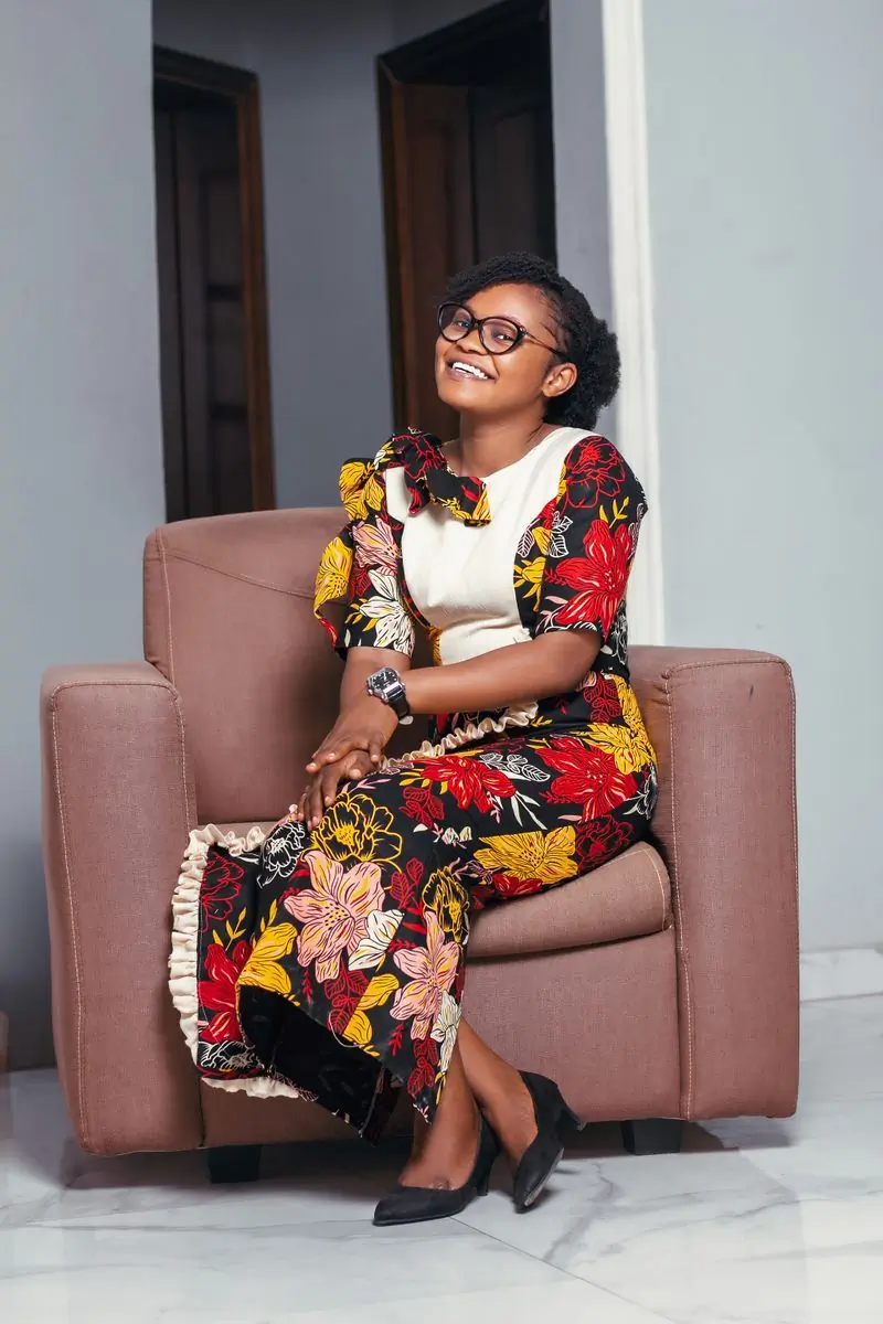 A customer seated in a printed dress and white blouse
