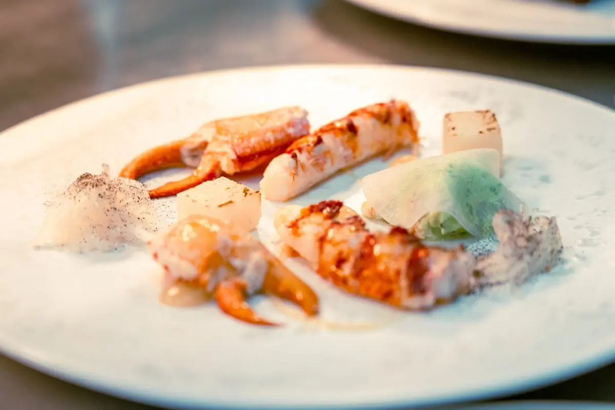 Crab claws dressed and plated at the pass