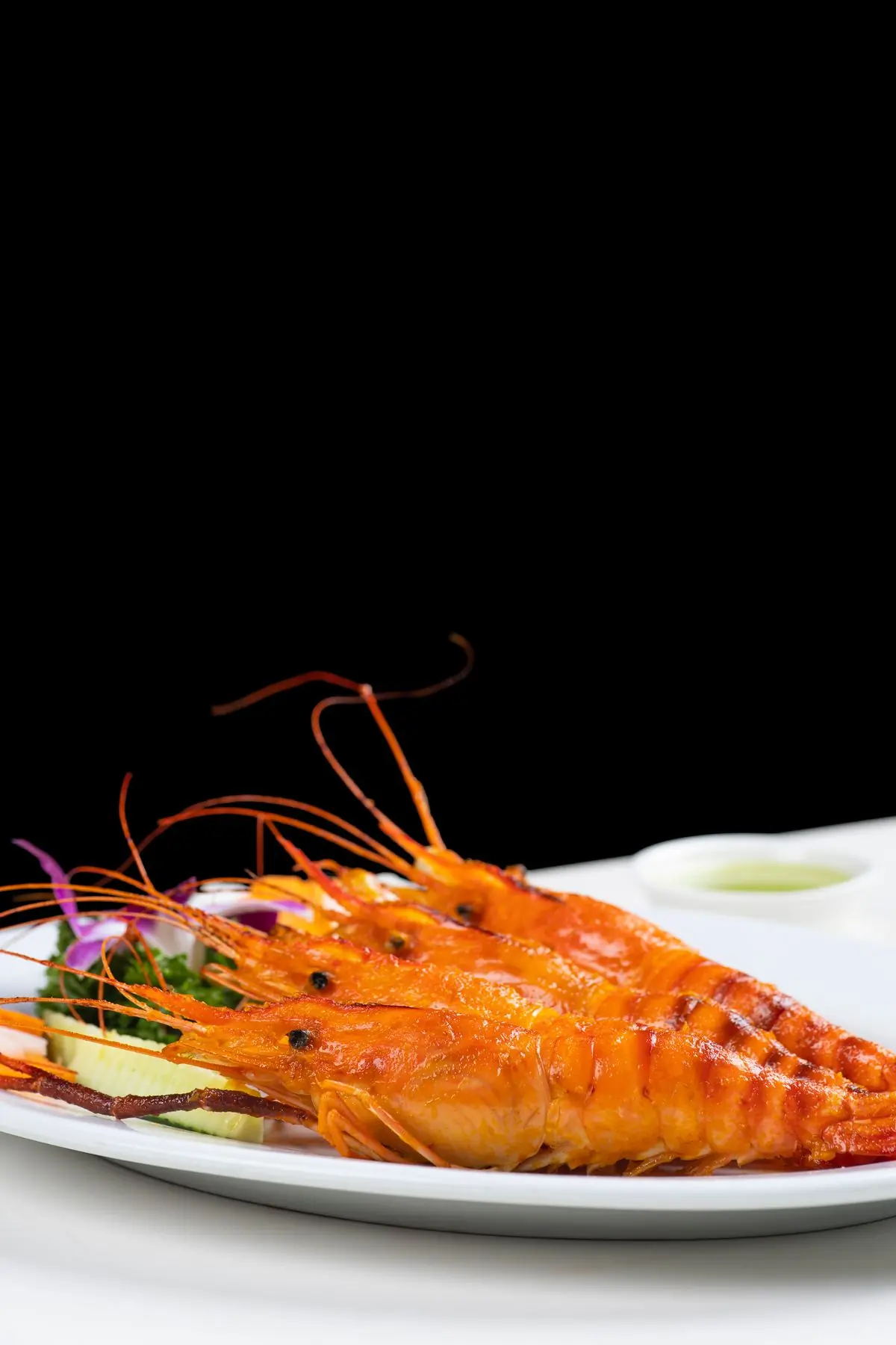 Grilled prawns laid out on a white plate