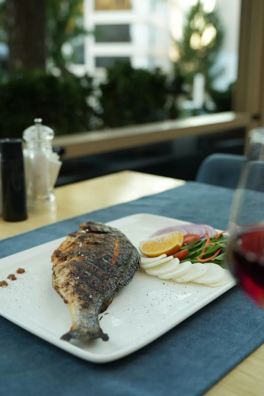 Grilled fish with vegetables and a glass of wine