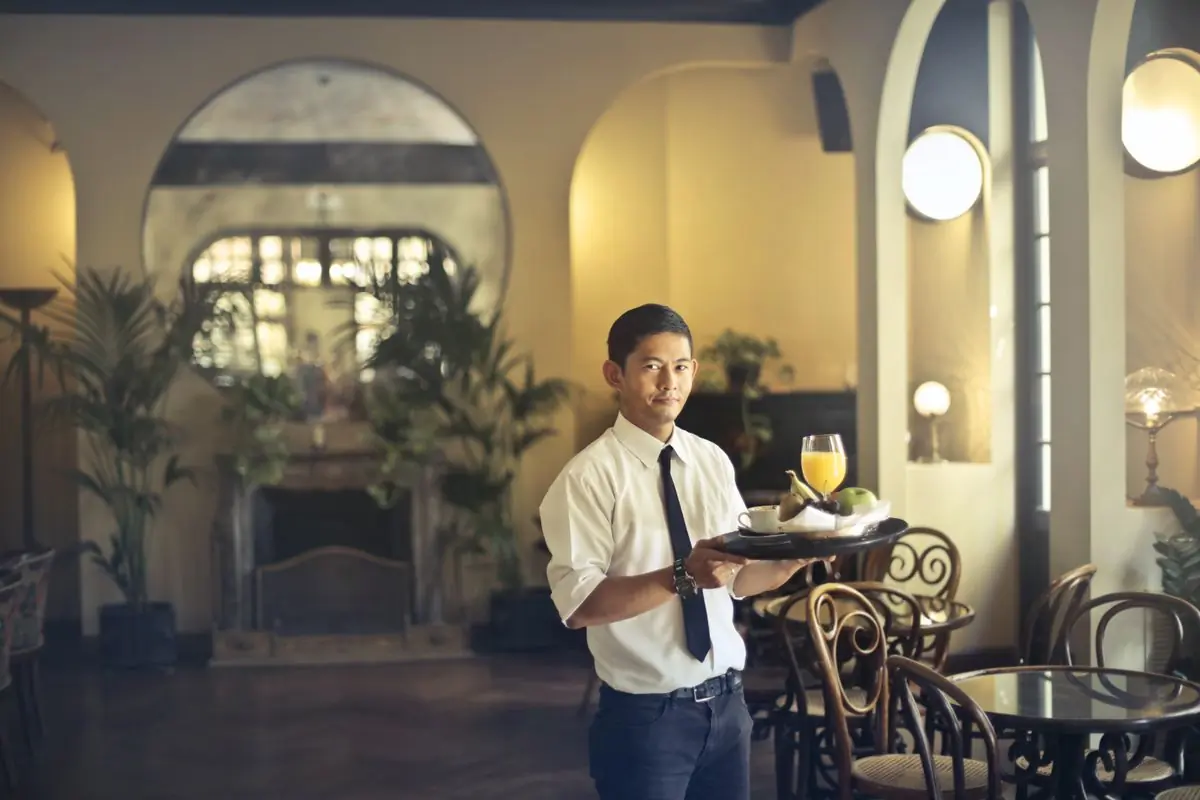 A member of the kitchen carrying plates through the room