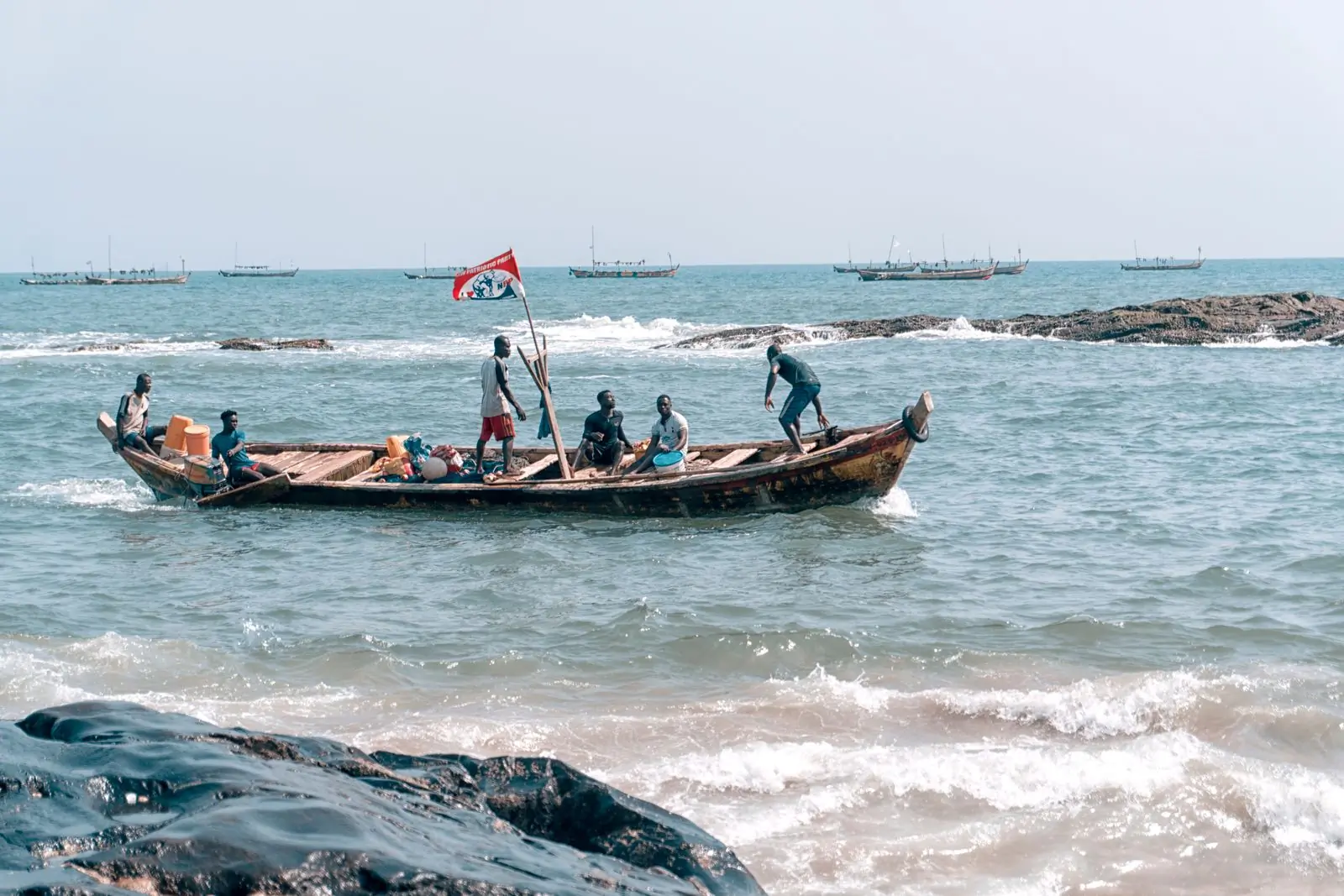 A wooden fishing boat running out through the surf