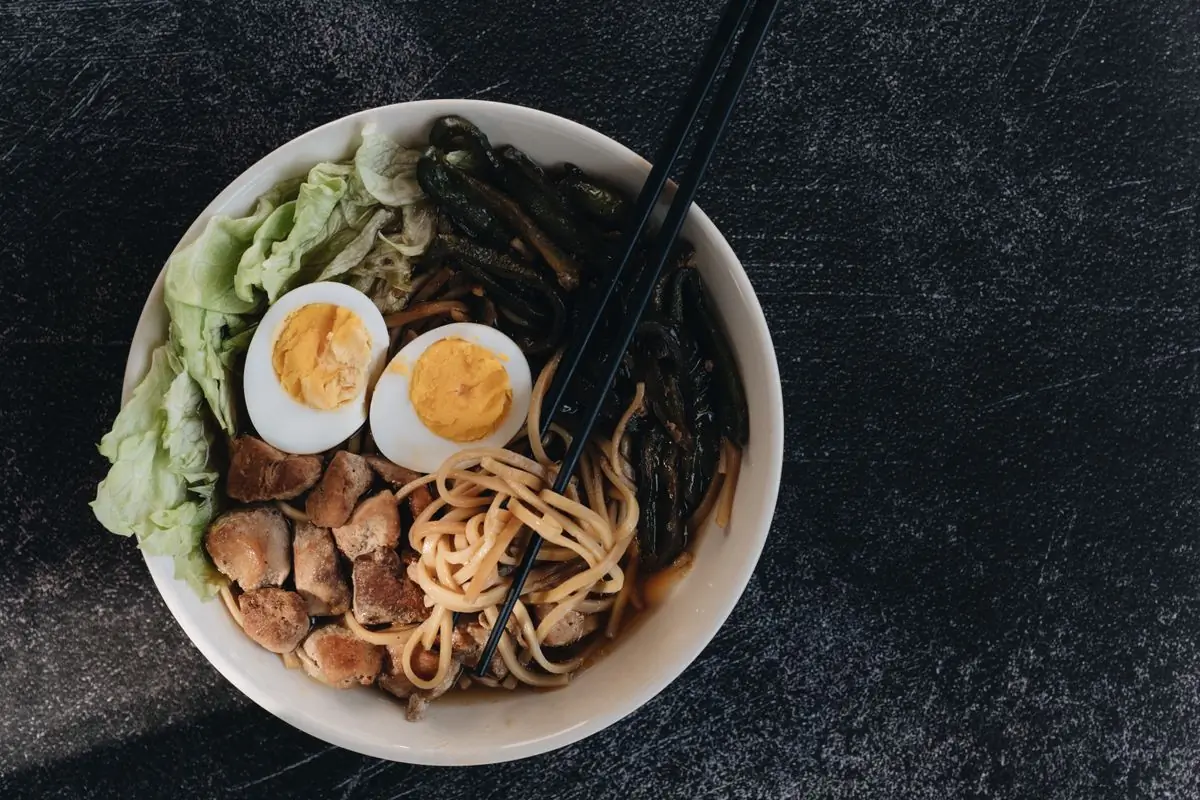 A bowl of ramen with soft eggs and spring onion, seen from above