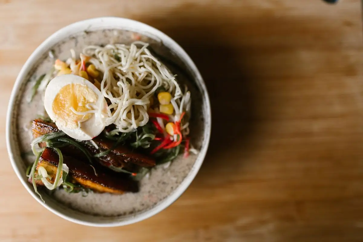 A white ceramic bowl of rice and cooked toppings