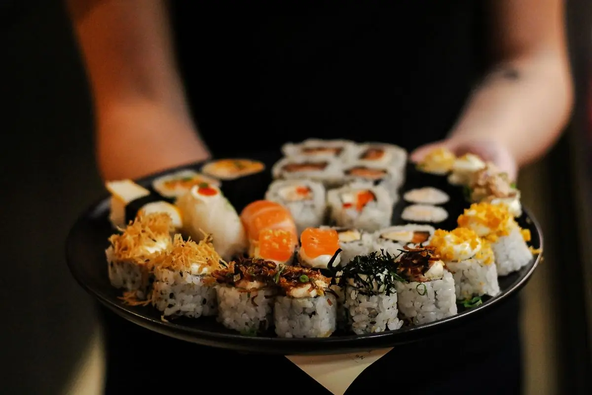 Assorted sushi rolls arranged on a black plate