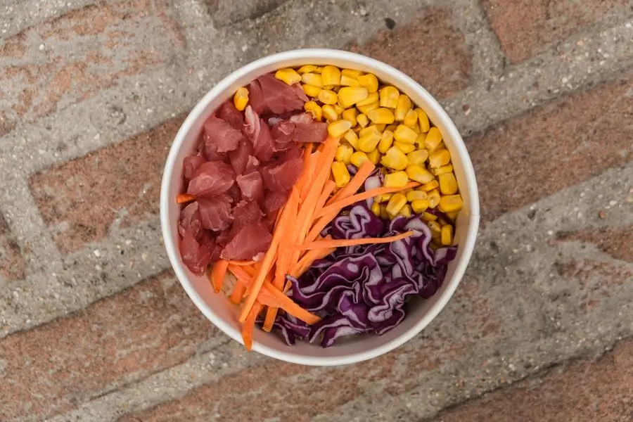 A poke bowl of rice, corn and greens seen from above