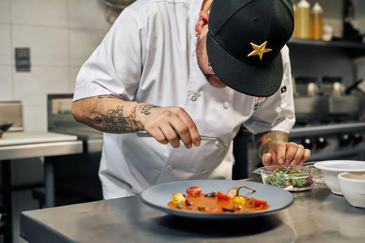 The head chef finishing a dish at the pass