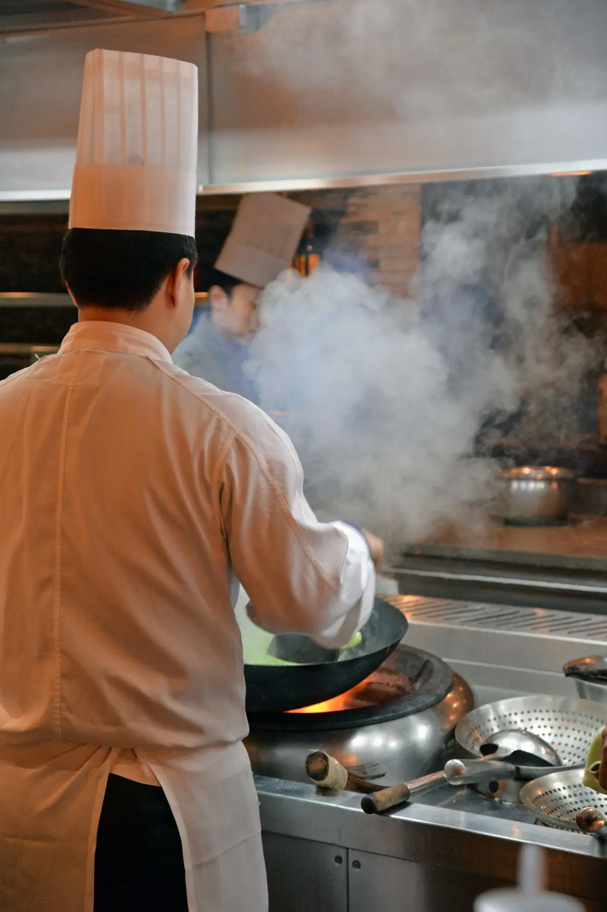 A cook working in the kitchen among steam