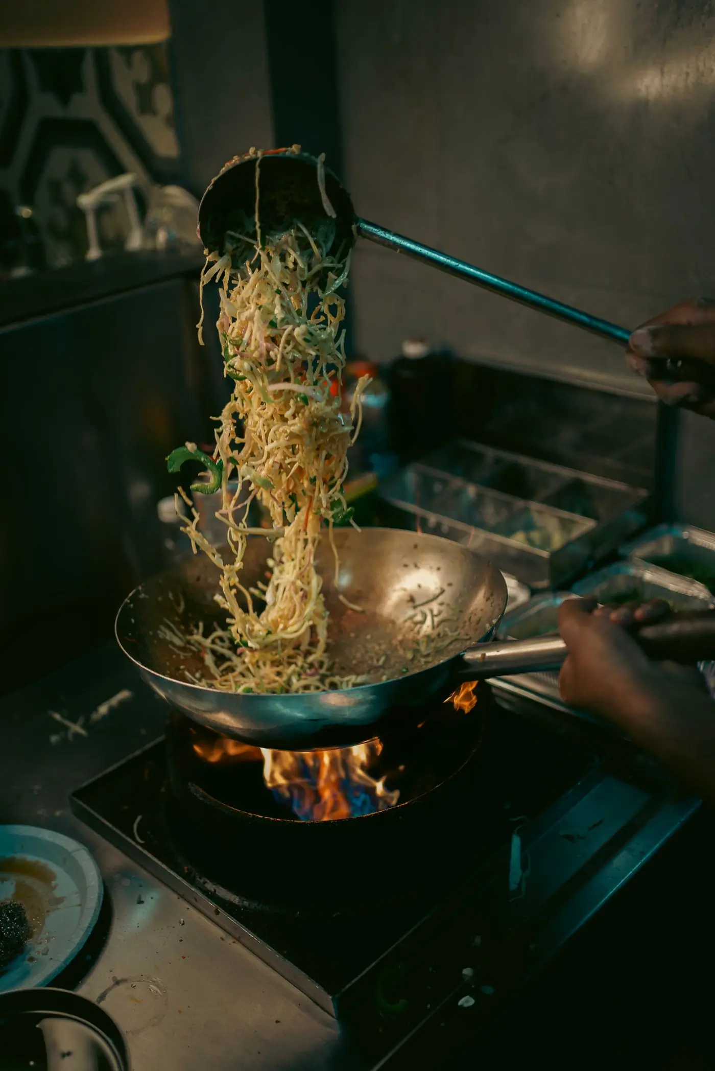 Noodles tossed in a wok over flames