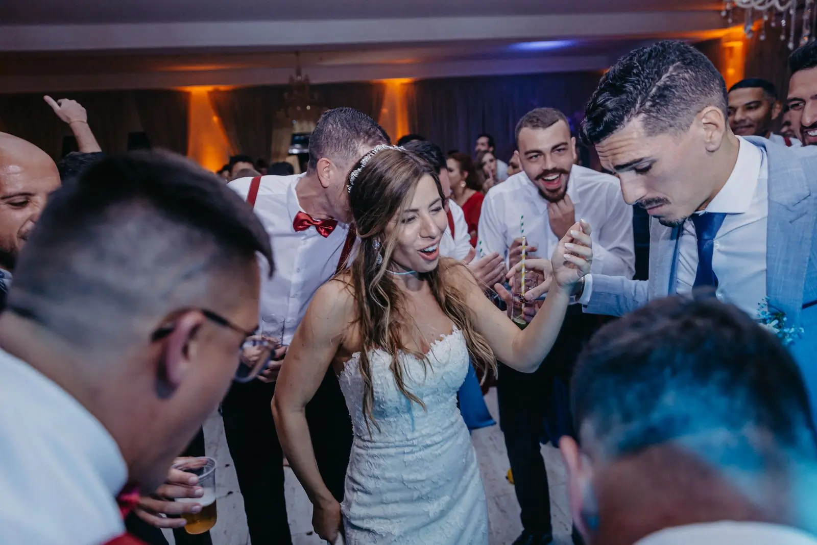 A crowd of wedding guests dancing closely together at a reception