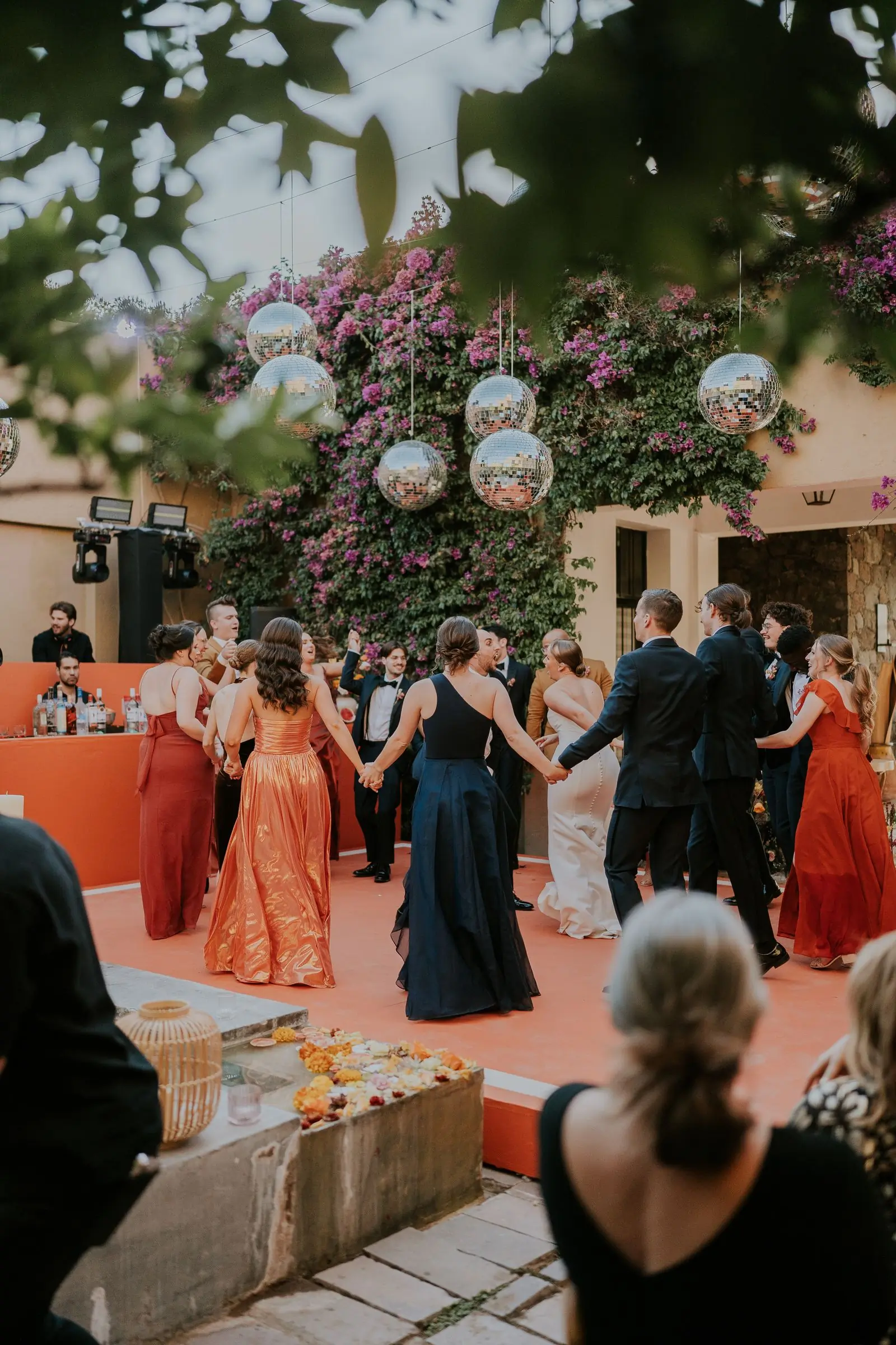 Wedding guests dancing together in a warmly lit reception room