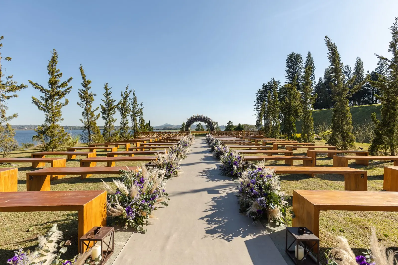 A long avenue of trees at a wedding venue running down towards water