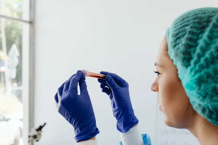 A technician handling a blood sample in the hospital laboratory
